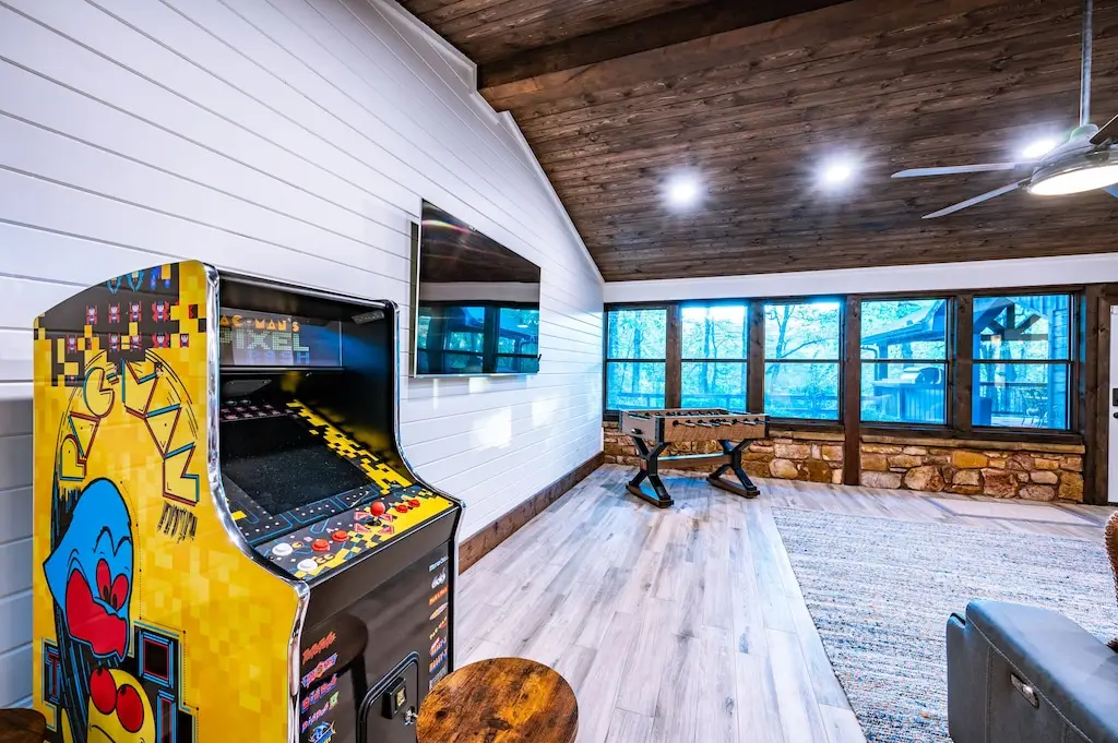 Game room has both an arcade game and foosball and shuffle board.