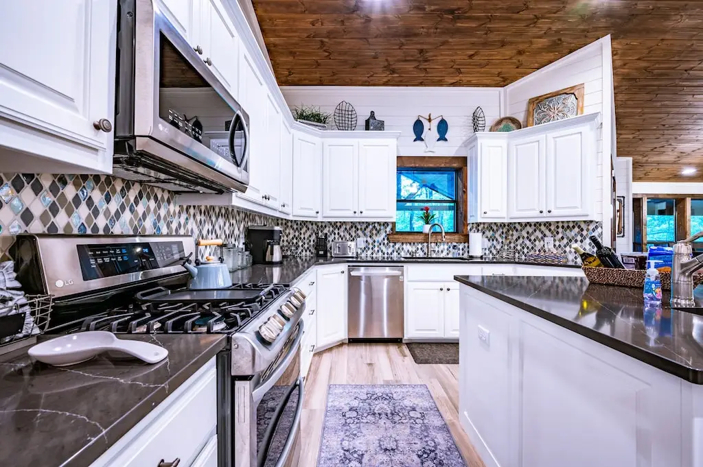 The kitchen is just around the corner from the bar area in the game room.