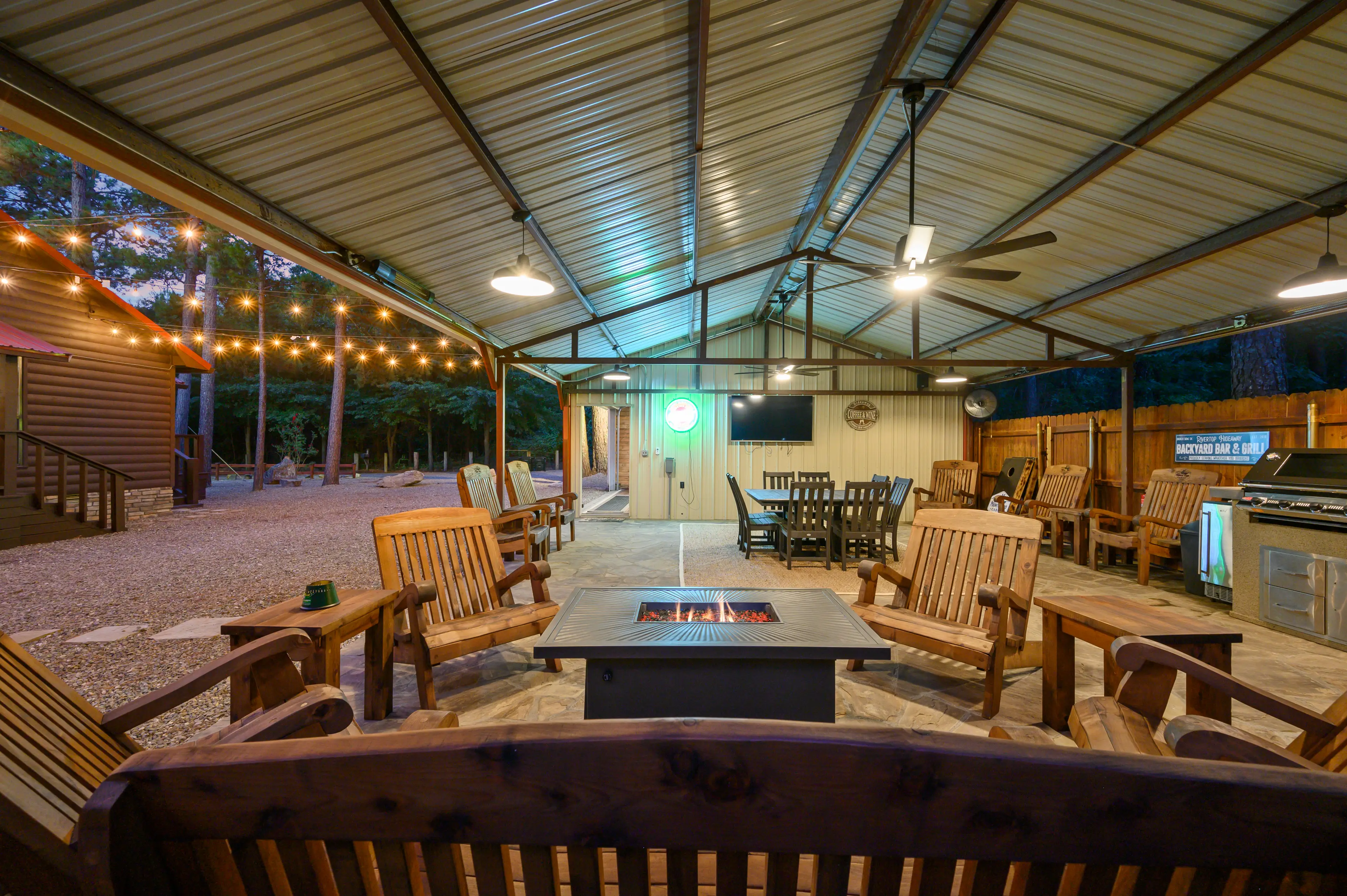 Outdoor living area with both a gas and propane grill, TV, fans, and dining table. You will be responsible for bringing your own charcoal and propane.